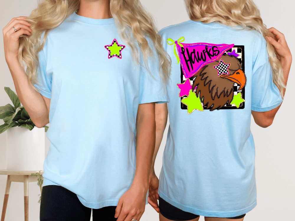 two women wearing light blue t-shirts with colorful designs on the back.