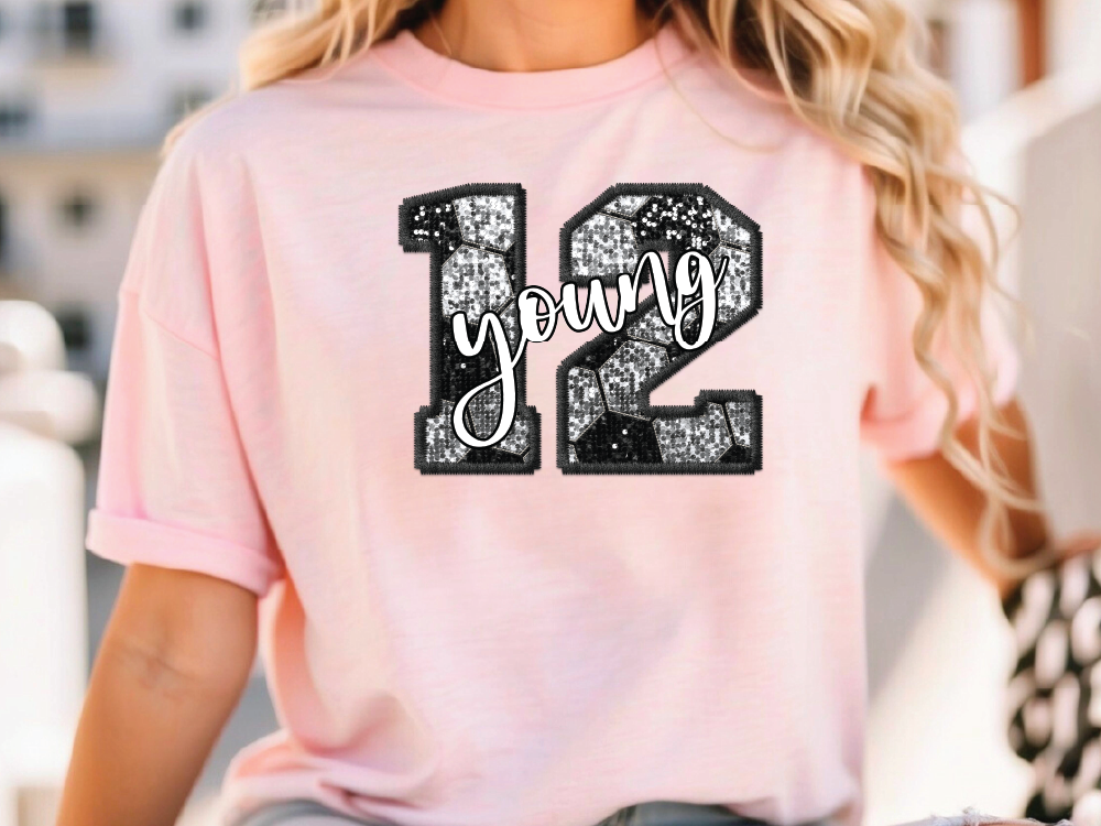 a woman wearing a pink t - shirt with the number twelve printed on it