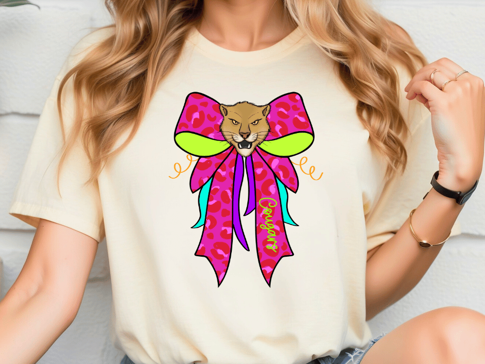 A woman wearing a white t-shirt with a colorful graphic design of a cat's face on it.