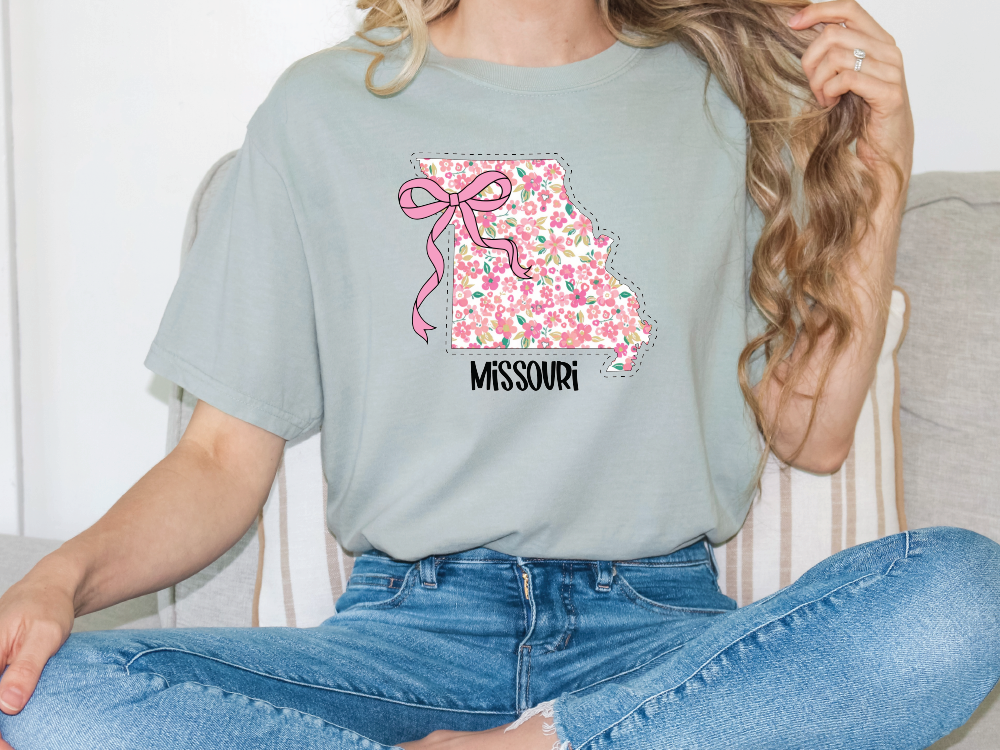 a woman sitting on a couch wearing a t - shirt with a mississippi map on
