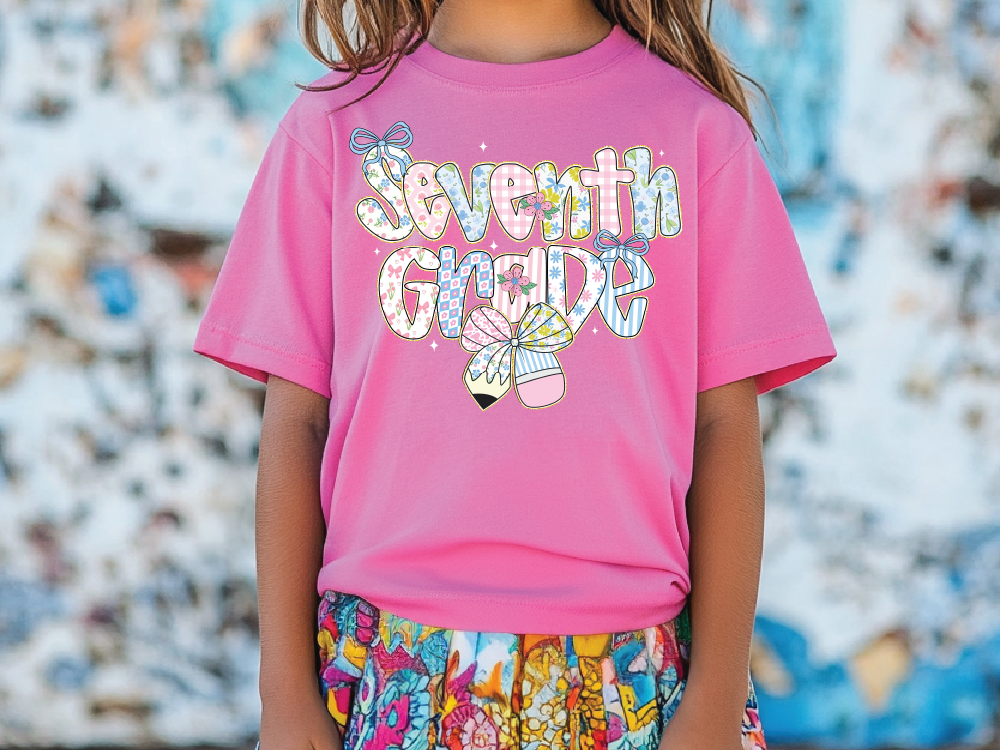 a little girl wearing a pink shirt that says seventh grade