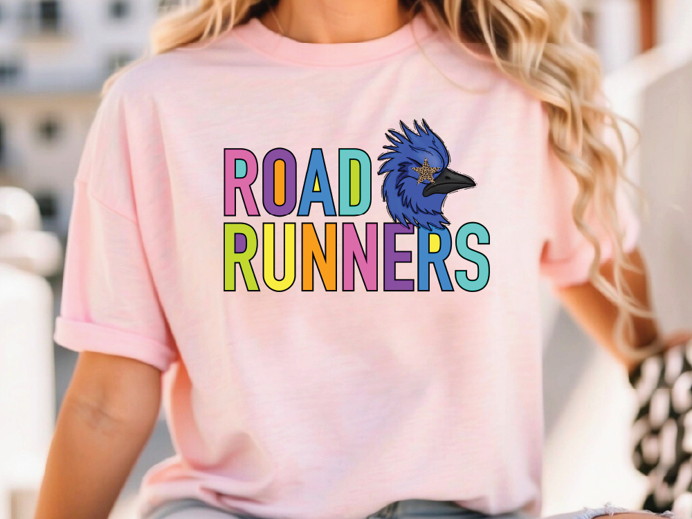A woman wearing a pink t-shirt with the text "ROAD RUNNERS" printed on it.