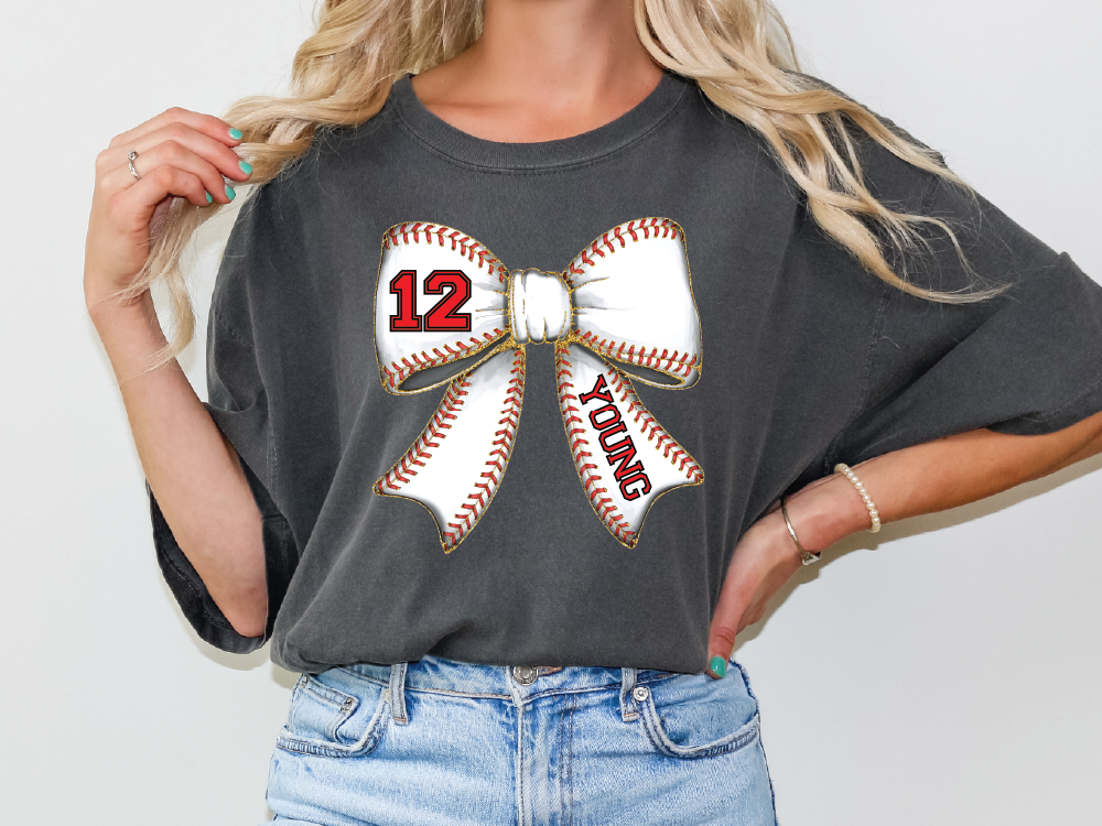 a woman wearing a gray shirt with a baseball bow on it