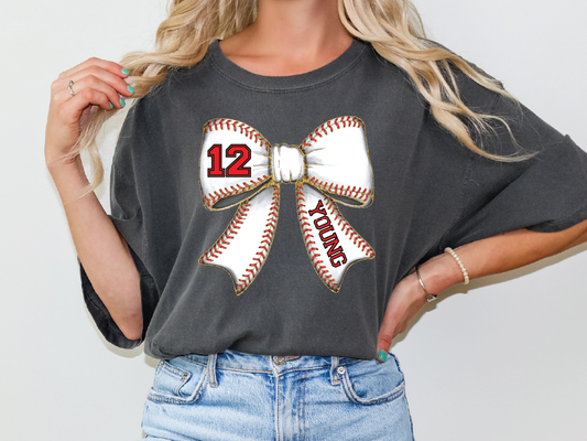 a woman wearing a gray shirt with a baseball bow on it