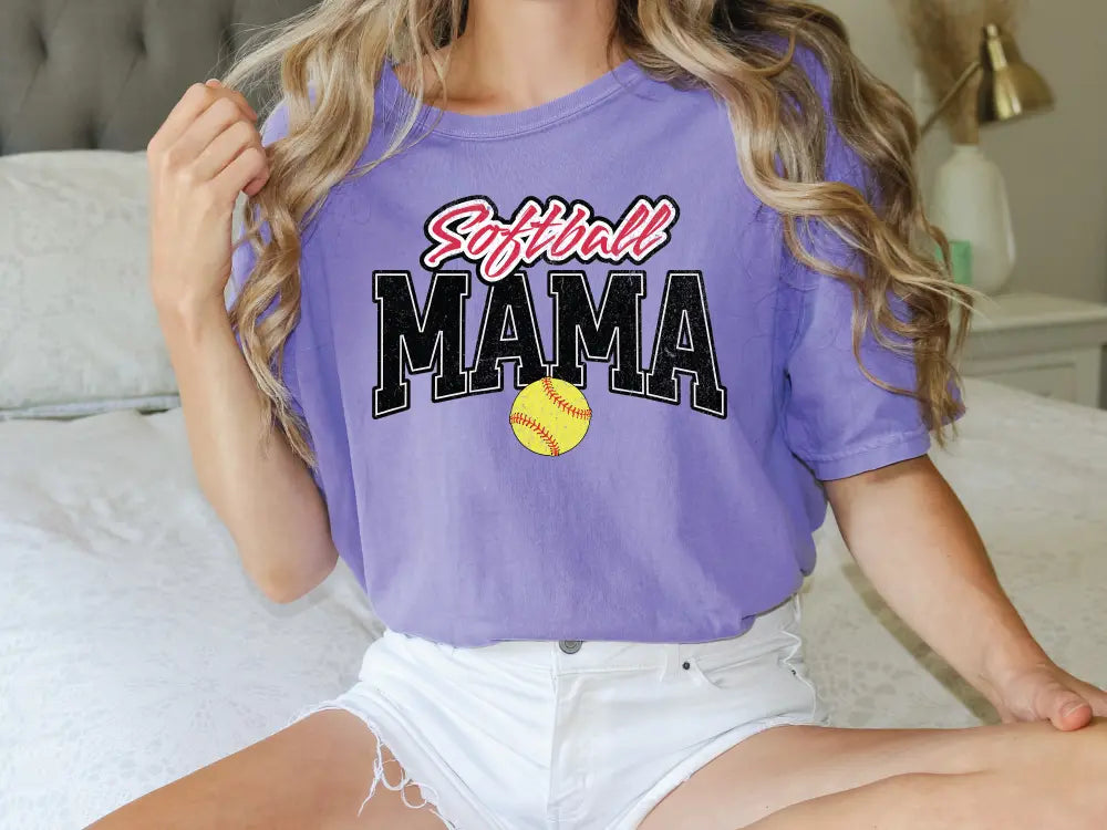 a woman sitting on top of a bed wearing a purple shirt