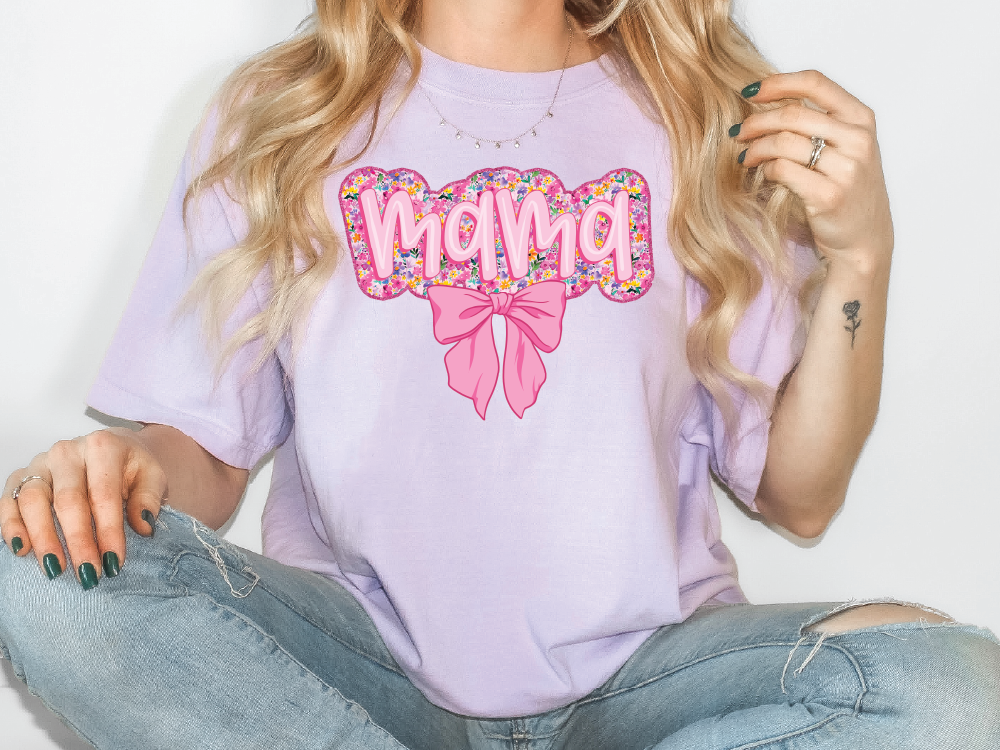 a woman sitting on the floor wearing a purple shirt with the word mom on it