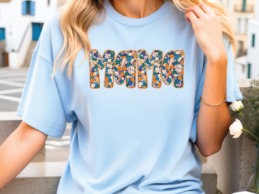 a woman wearing a blue shirt with the word mom printed on it