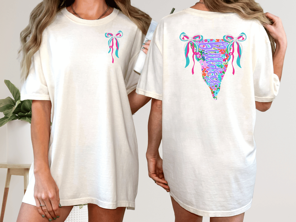 two women wearing white t-shirts with colorful floral designs on the back.