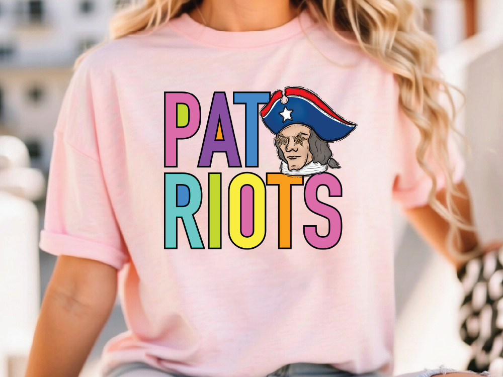A woman wearing a pink t-shirt with the text "Patriots" and a cartoon depiction of a man in a patriotic hat.