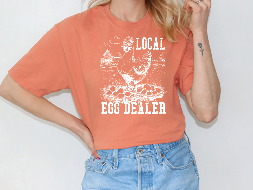 a woman wearing an orange local egg dealer t - shirt