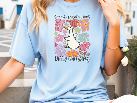 a woman sitting on a ledge wearing a blue shirt with a duck on it