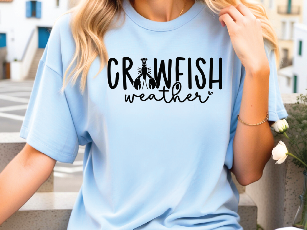 a blonde woman wearing a blue crewfish weather t - shirt
