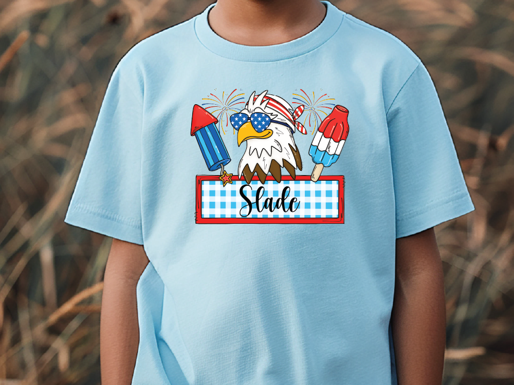a young boy wearing a blue shirt with an eagle on it