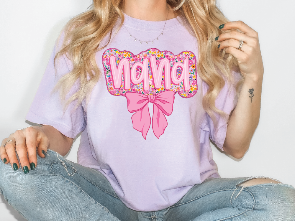 a woman sitting on the floor wearing a purple shirt with a pink bow