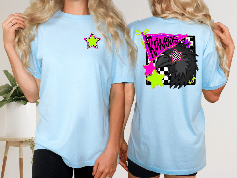two women wearing light blue t-shirts with colorful designs on the back.