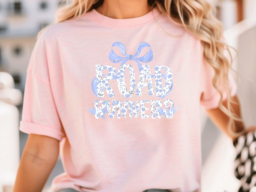 A woman wearing a pink t-shirt with the text "Road Runners" printed on it.