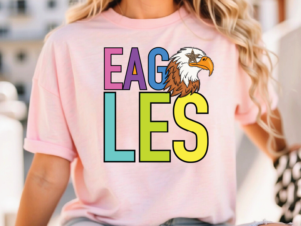 A woman wearing a pink t-shirt with the word "EAGLES" printed on it, along with an illustration of an eagle.