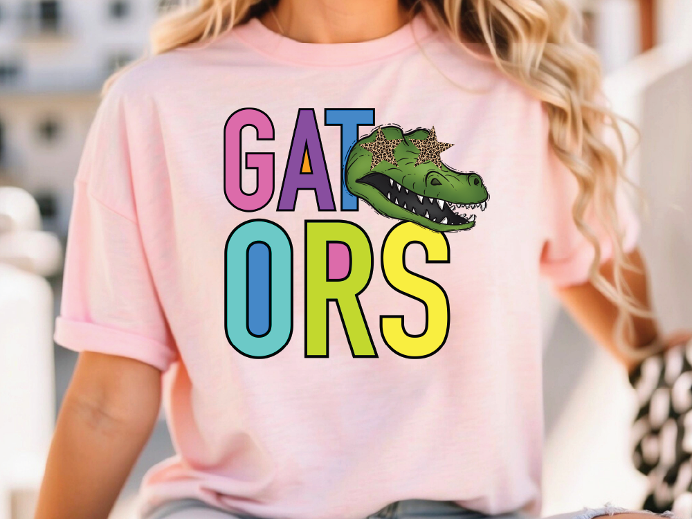 A person wearing a pink t-shirt with the text "GATORS" and a cartoon alligator graphic.