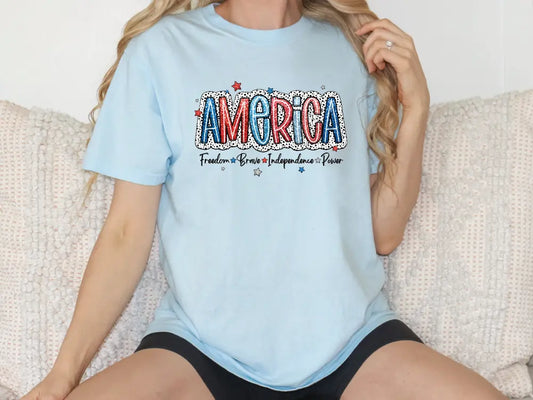 a woman sitting on a couch wearing a t - shirt that says america