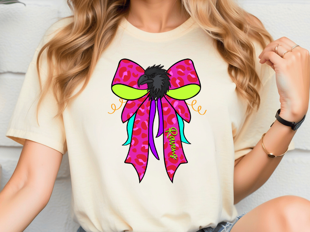 A woman wearing a white t-shirt with a colorful bow graphic and the word "Rainbow" printed on it.