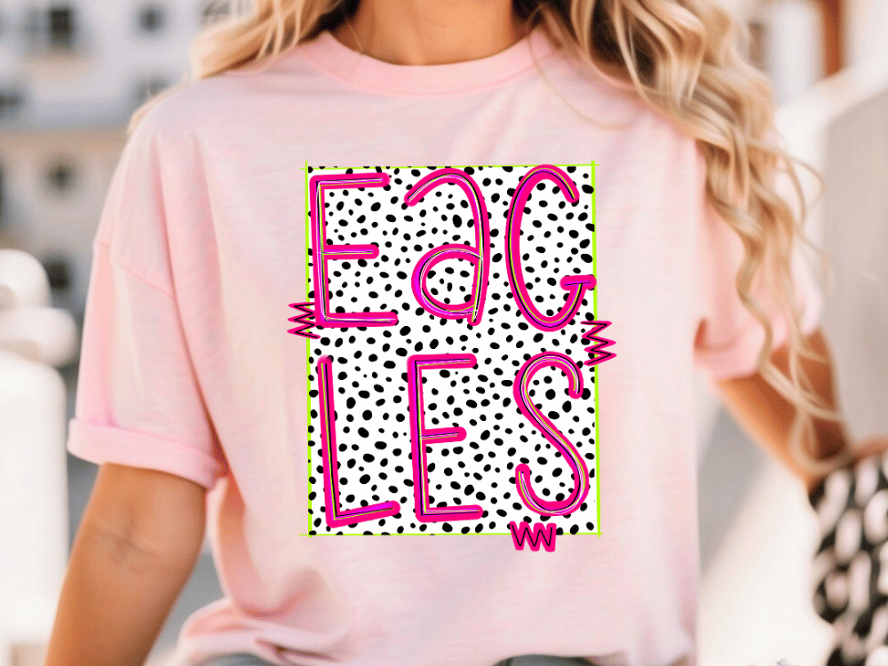 A woman wearing a pink t-shirt with a graphic design featuring the word "EAGLES" in pink and black, with a dotted pattern.