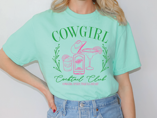 a woman wearing a green cowgirl tee shirt