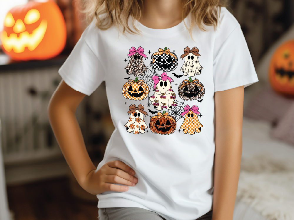 A person wearing a white t-shirt with a graphic design of various Halloween-themed characters, including pumpkins, ghosts, and bats.