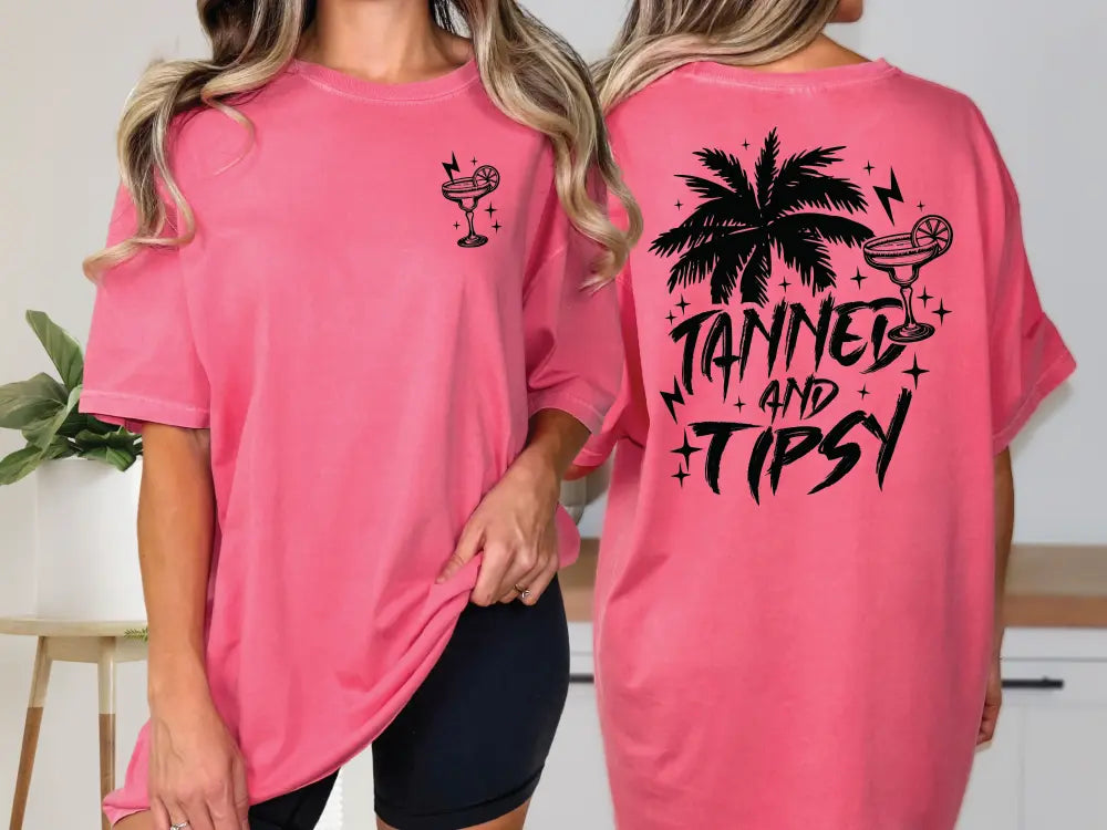 two women wearing pink shirts with black writing on them