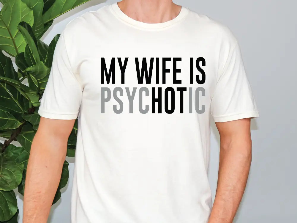 a man wearing a white shirt that says my wife is psychic