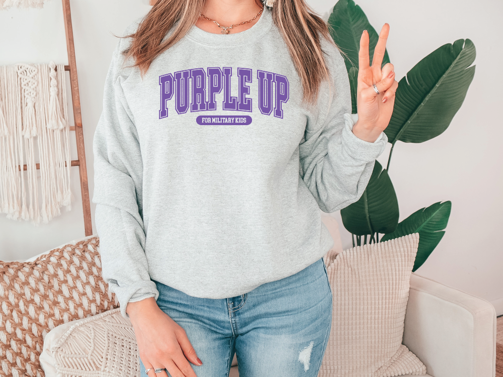 a woman wearing a sweatshirt that says purple up