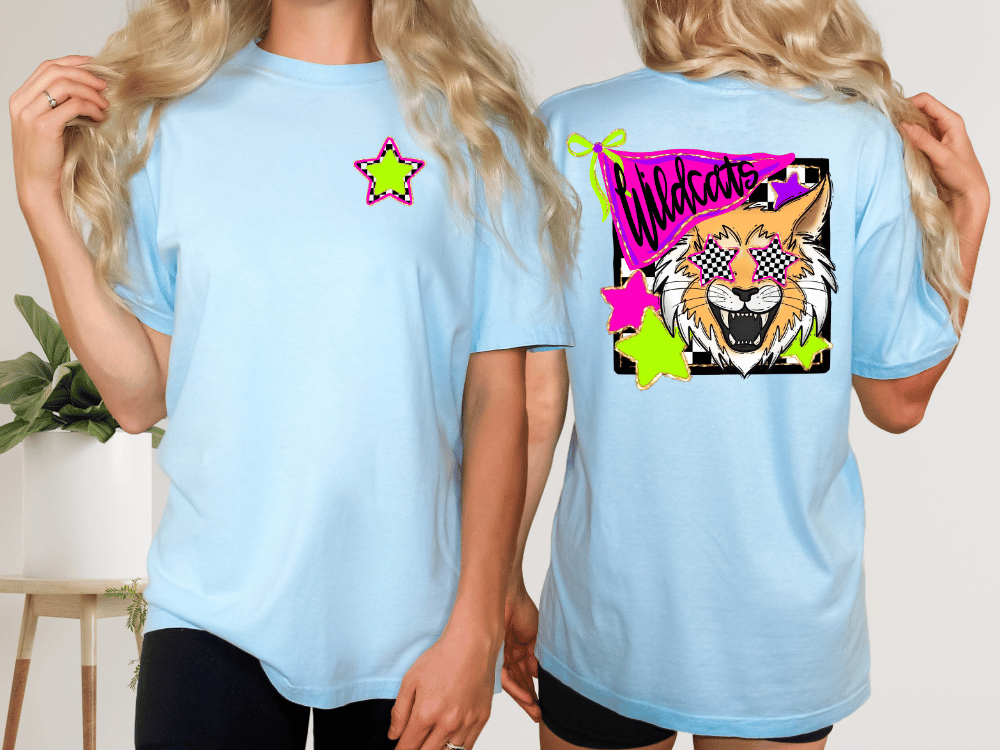 A woman wearing a light blue t-shirt with a graphic design featuring a cartoon-style cat and colorful stars.