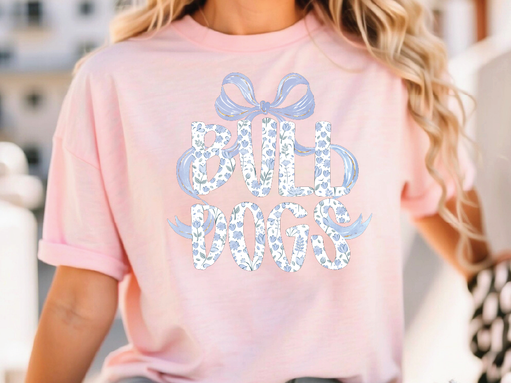 A woman wearing a pink t-shirt with the text "Bull Dogs" printed on it.