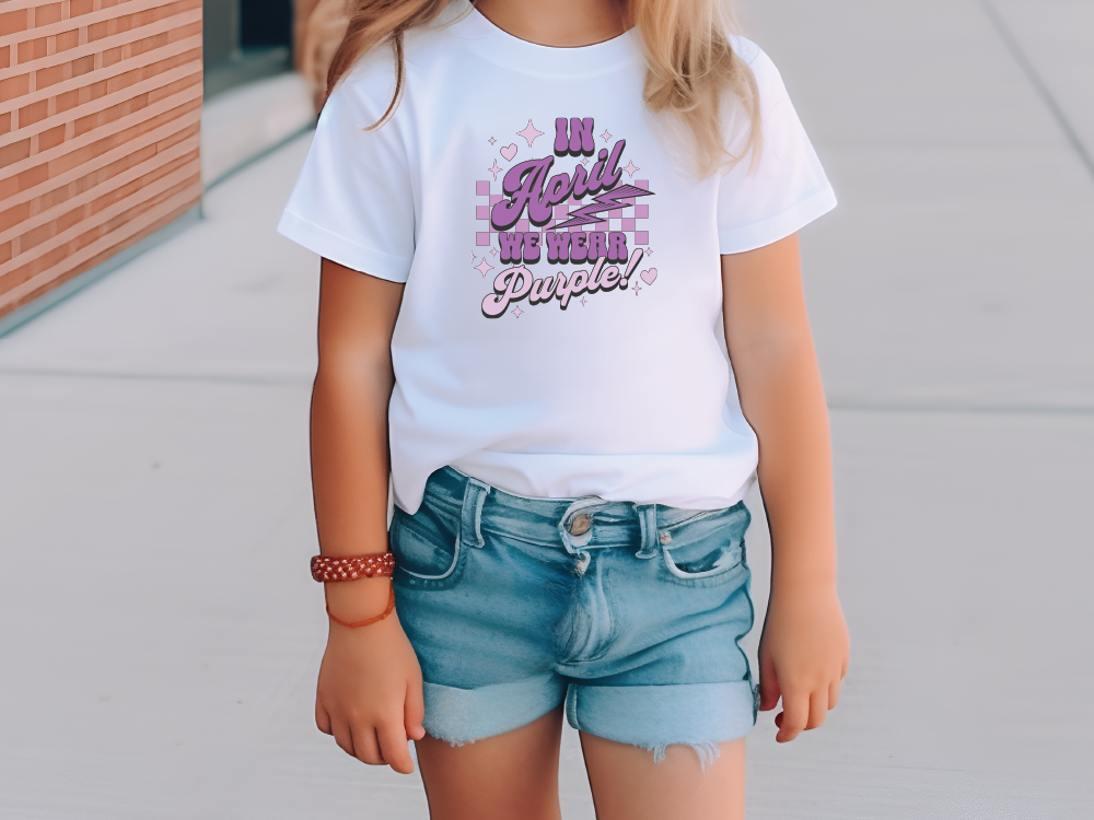 a little girl wearing a white shirt and denim shorts