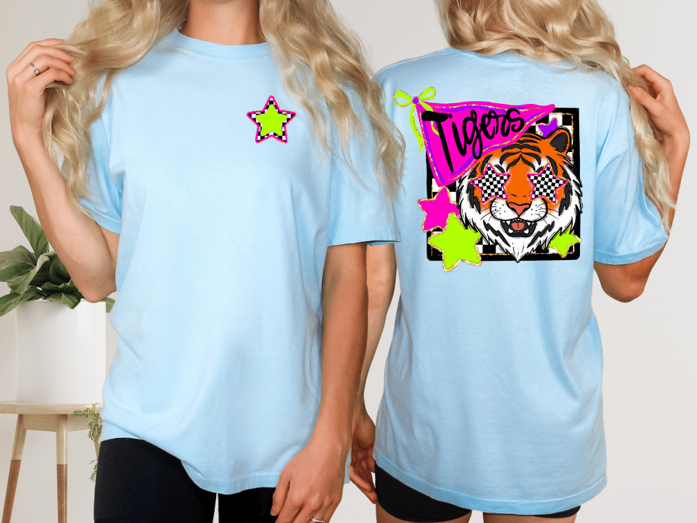 A woman wearing a light blue t-shirt with a graphic design of a tiger wearing sunglasses and surrounded by colorful stars.