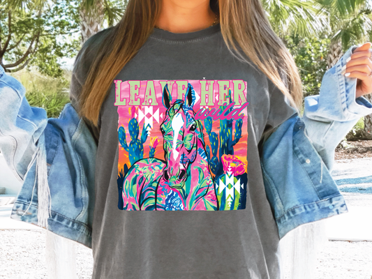 a woman wearing a gray shirt with a picture of a horse on it