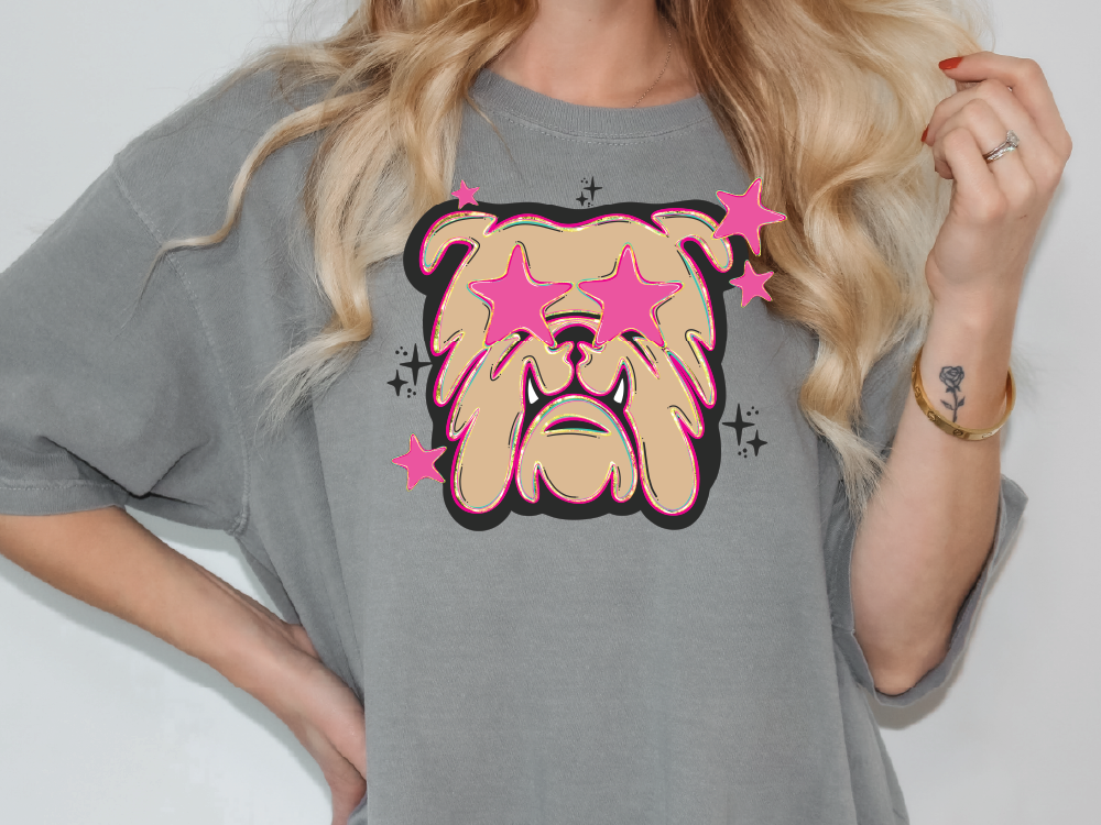 A woman wearing a gray t-shirt with a graphic design of a bulldog and pink stars on it.