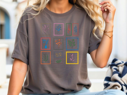 a woman sitting on a bench wearing a t - shirt with flowers on it