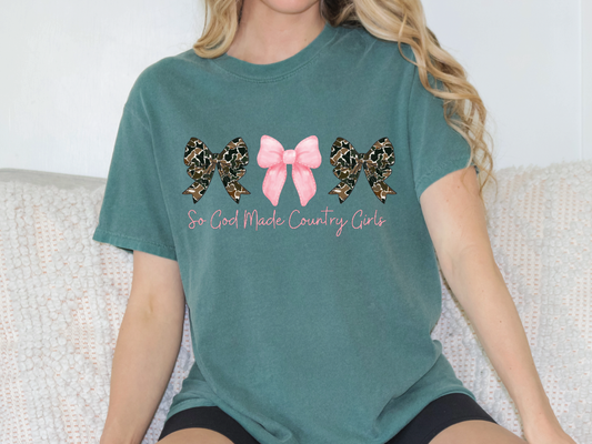 a woman sitting on a couch wearing a green shirt with a pink bow