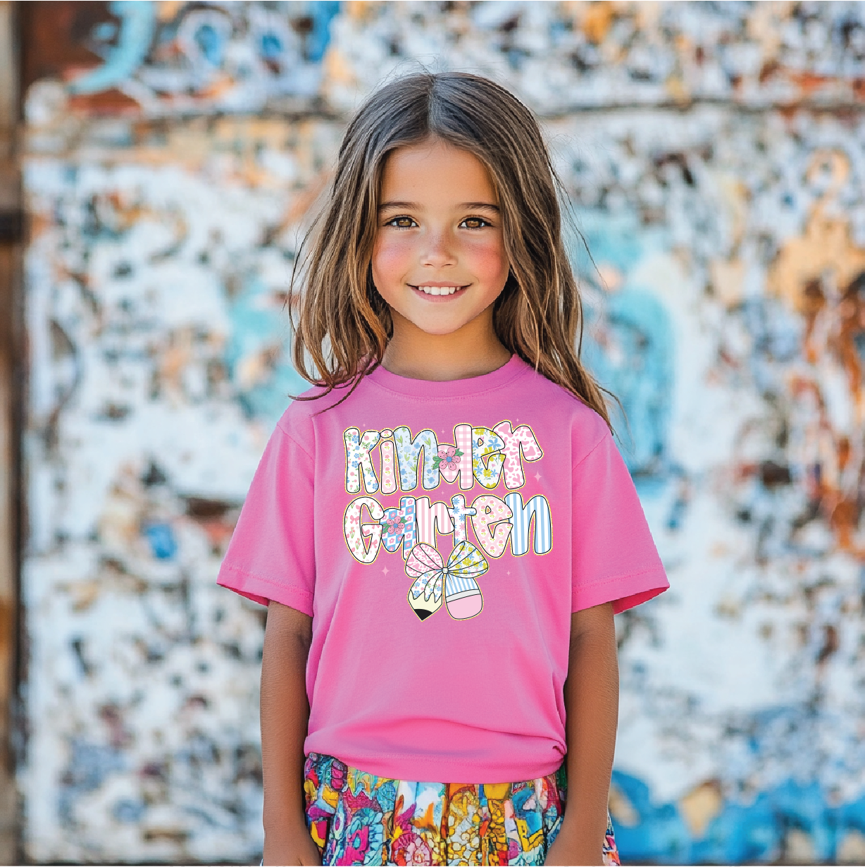 a little girl standing in front of a graffiti covered wall