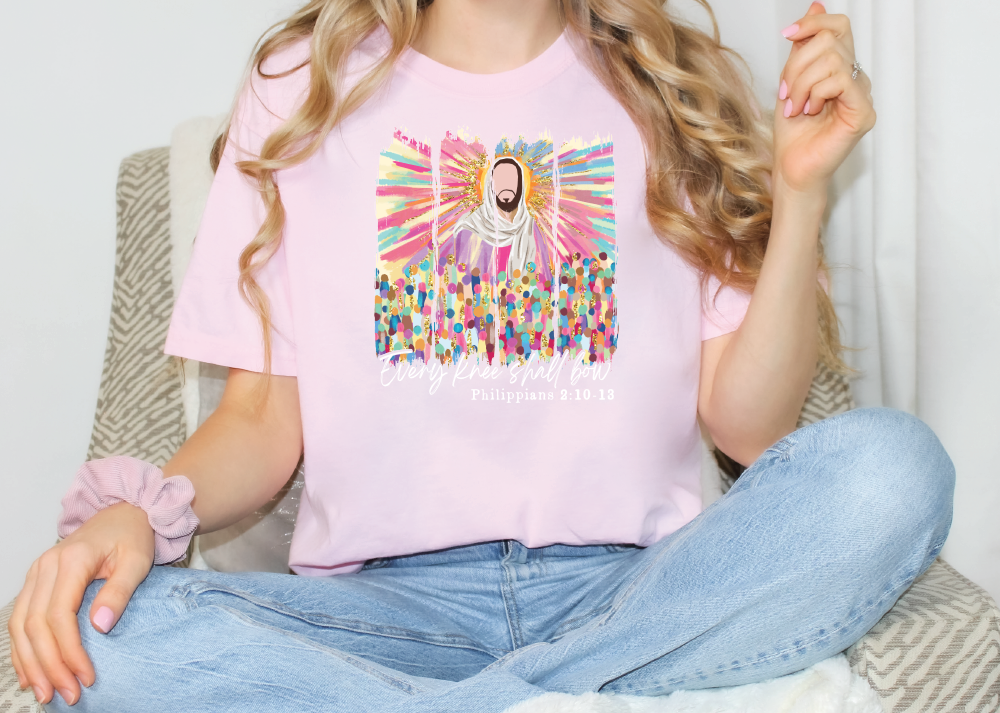 a woman sitting on a chair wearing a pink shirt