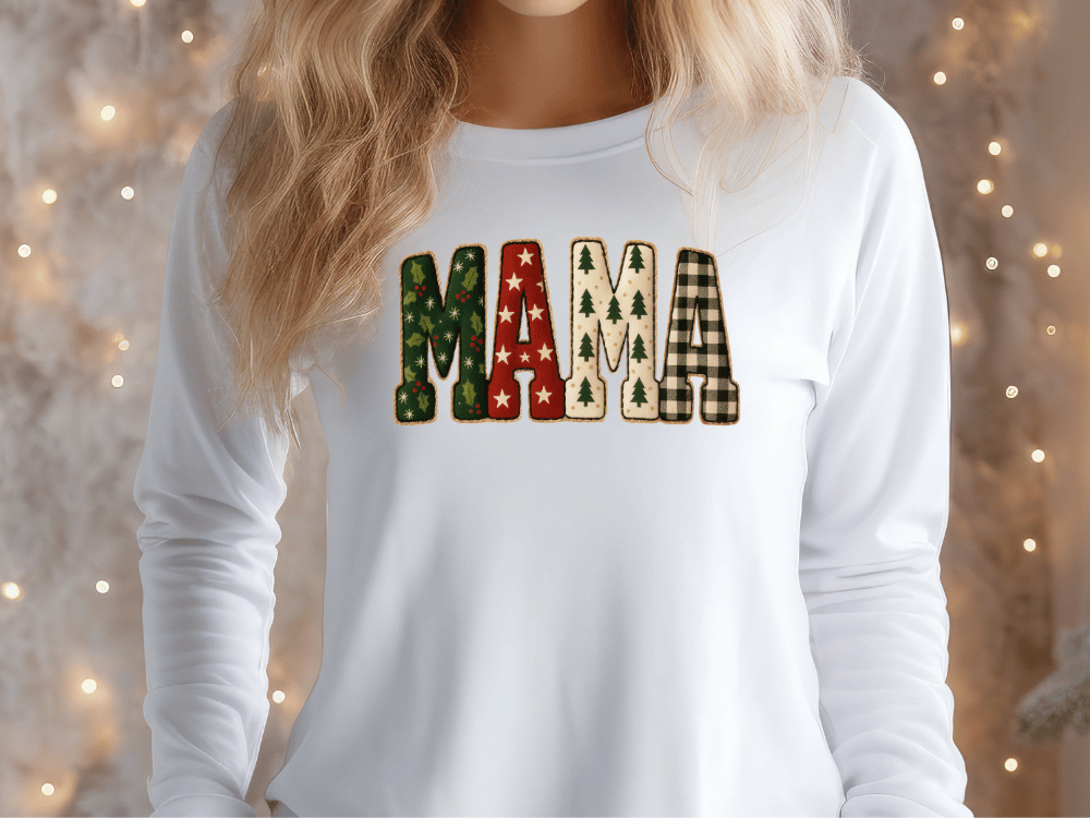 A woman wearing a white long-sleeved shirt with the word "MAMA" printed on it in a festive, holiday-themed font.