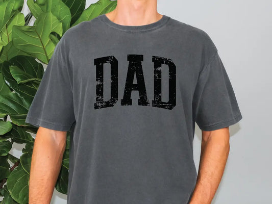 a man standing in front of a plant with the word dad printed on it