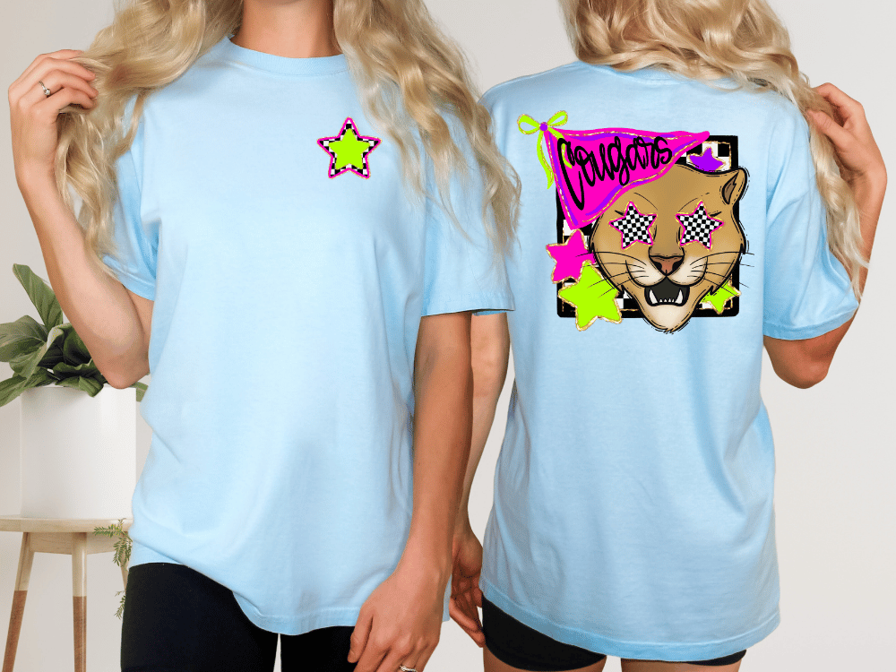 two women wearing light blue t-shirts with a graphic design on the back.
