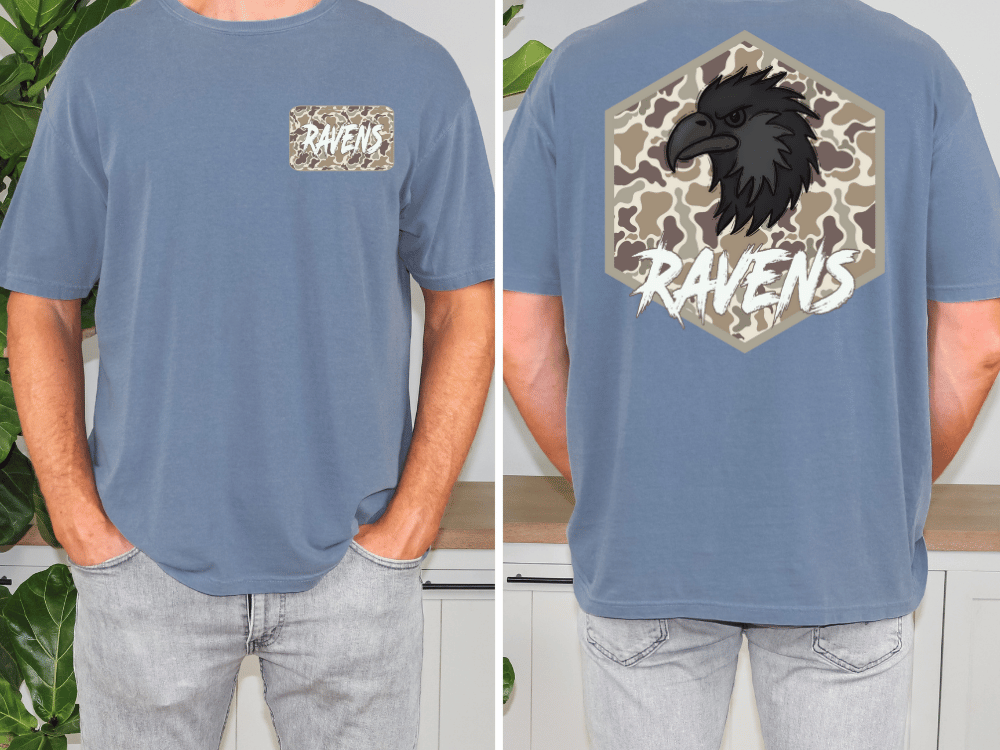 a man wearing a blue t-shirt with a graphic design on the back. The design features a black bird, likely a raven, with a camouflage pattern. The word "RAVENS" is written above the bird.