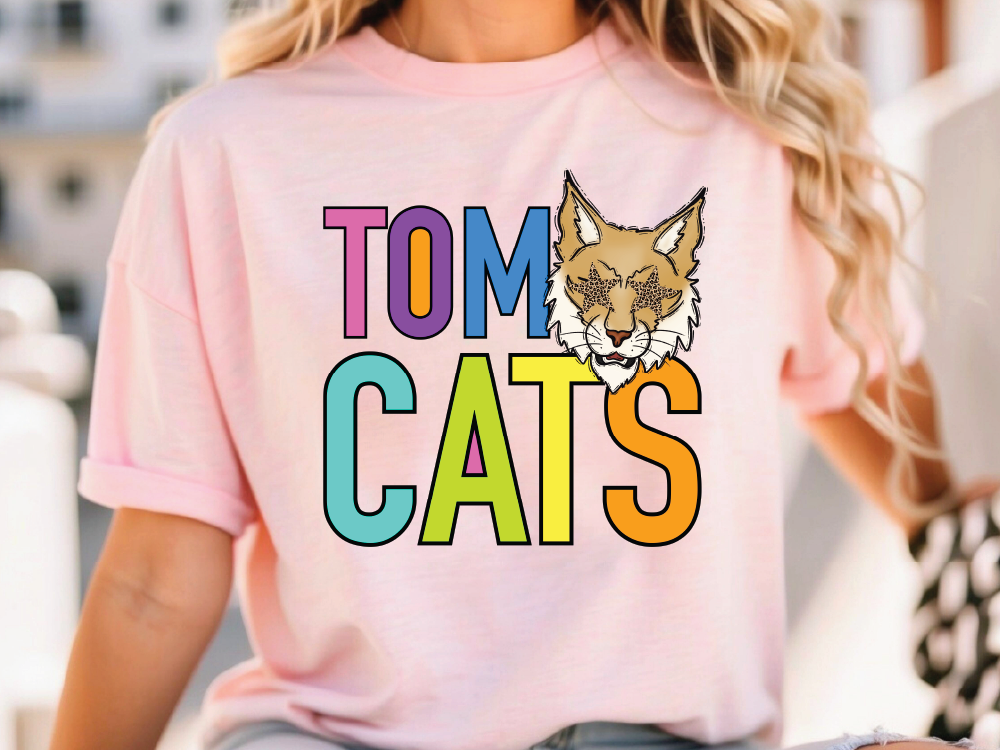 A person wearing a pink t-shirt with the text "TOM CATS" and an illustration of a cat's face.