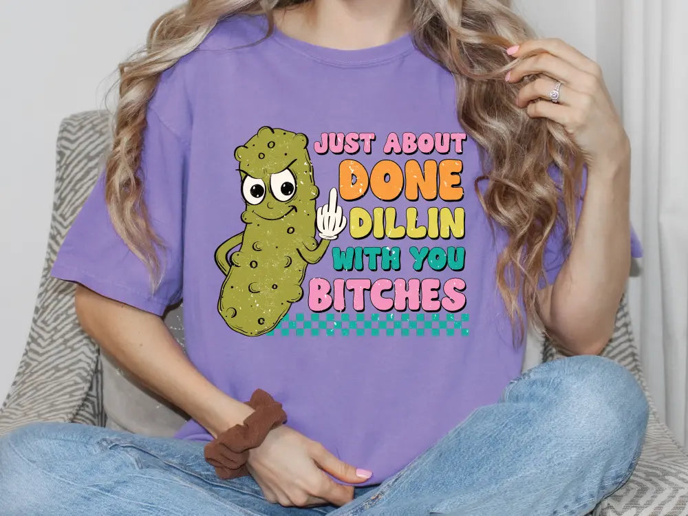 a woman sitting on a couch wearing a purple shirt