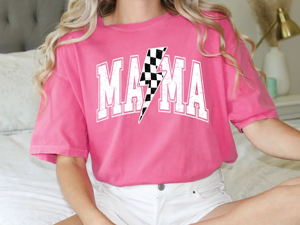 a woman sitting on a bed wearing a pink shirt
