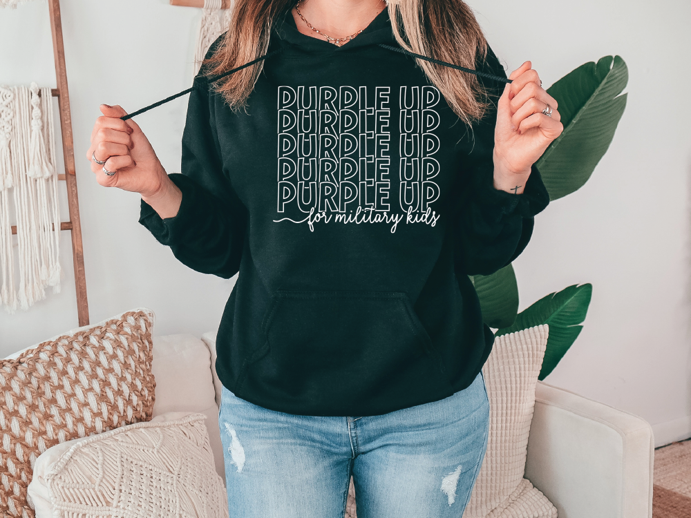 a woman in a black hoodie holding a green leaf