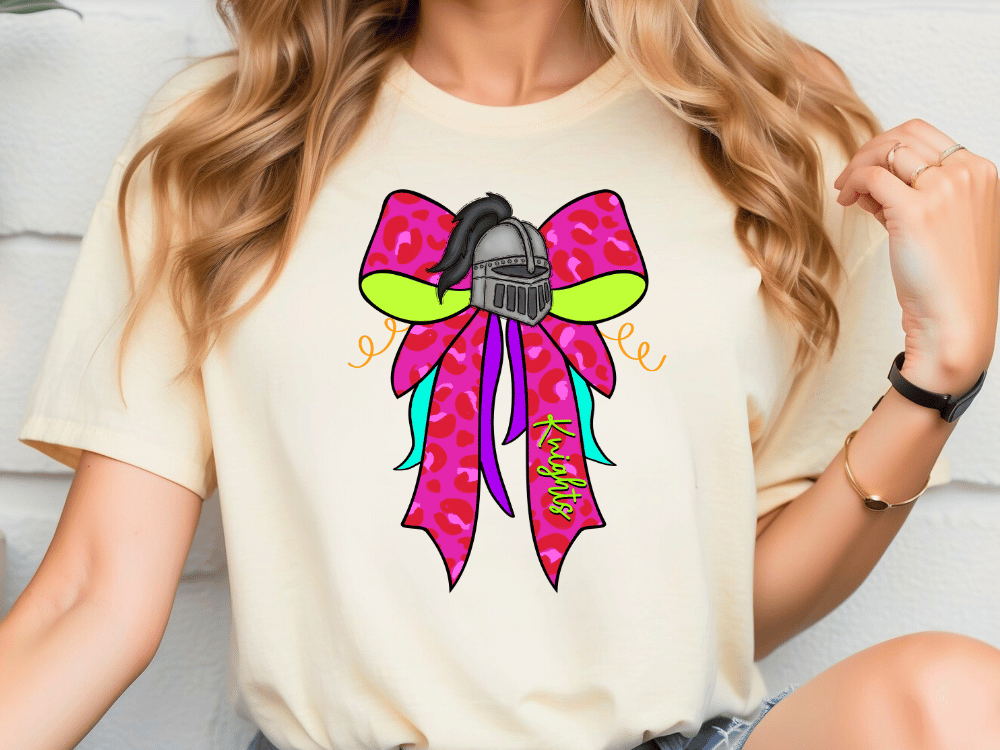 A woman wearing a white t-shirt with a colorful graphic design featuring a bow and a helmet.
