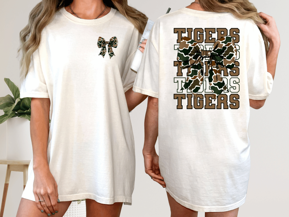 A woman wearing a white t-shirt with a bow and the word "TIGERS" printed on the back.